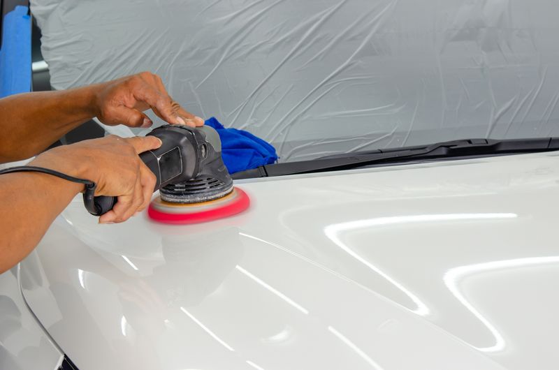 Machine polishing a white car bonnet